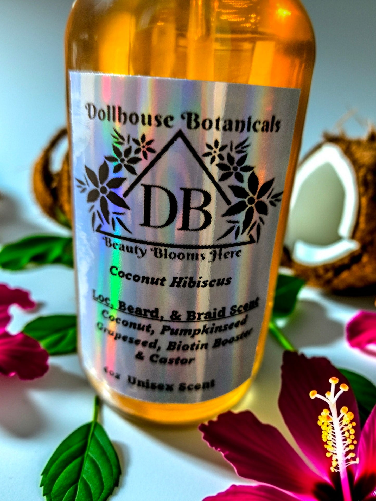 Bottle of Dollhouse Botanicals Coconut Hibiscus Loc, Beard, and Braid Scent. Golden oil in glass bottle. Front facing with label and ingredients displayed. Unisex hair fragrance.