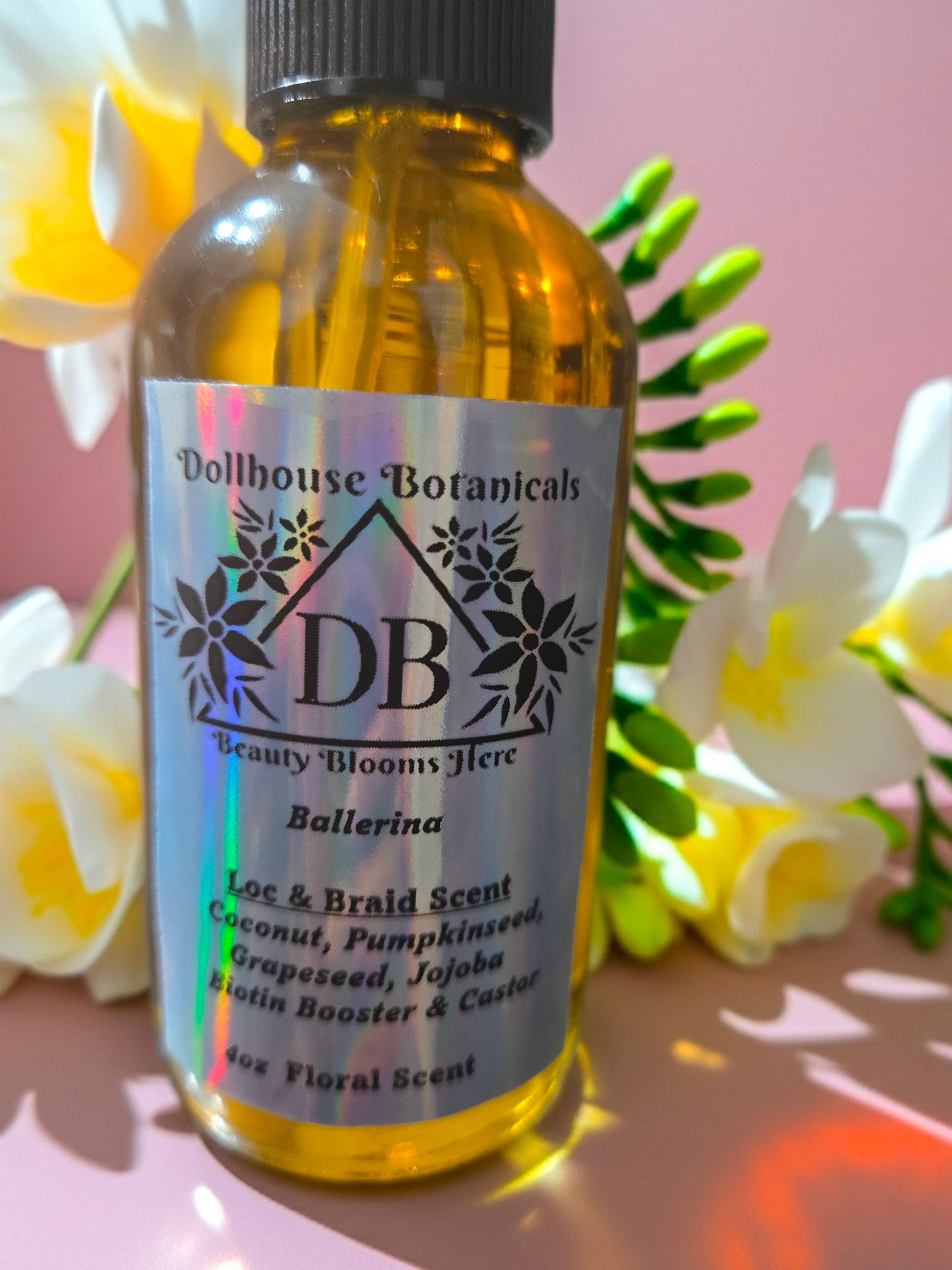 Bottle of Dollhouse Botanicals Ballerina Loc and Braid Scent. Golden oil in glass bottle. Front facing with label and ingredients displayed. Feminine Hair Scent.