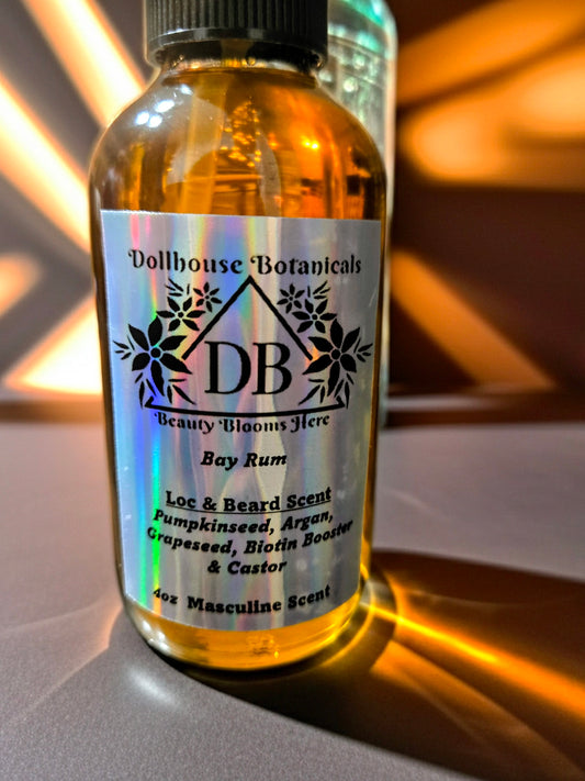 Bottle of Dollhouse Botanicals Bay Rum Loc and Beard Scent. Golden oil in glass bottle. Front facing with label and ingredients displayed.