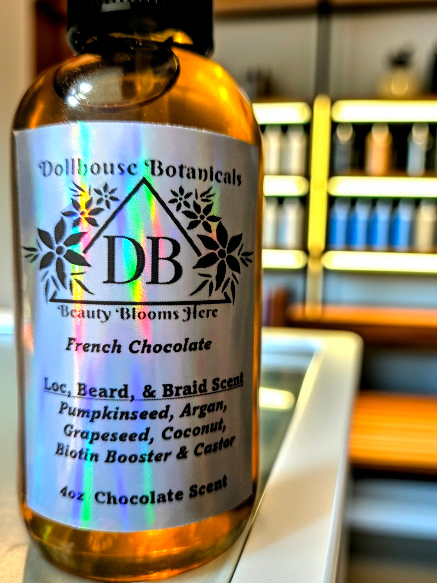  Dollhouse Botanicals French Chocolate Loc, Beard, and Braid Scent. Golden oil in glass bottle. Front facing with label and ingredients displayed. Unisex hair fragrance.
