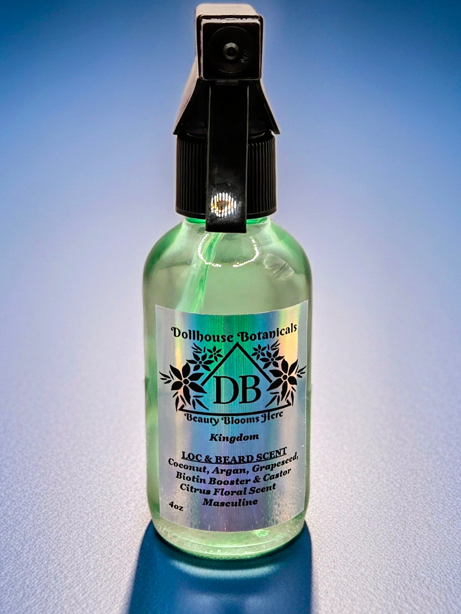 Bottle of Dollhouse Botanicals Kingdom Loc and Beard Scent. Oil in clear bottle with black trigger sprayer. Masculine scent .