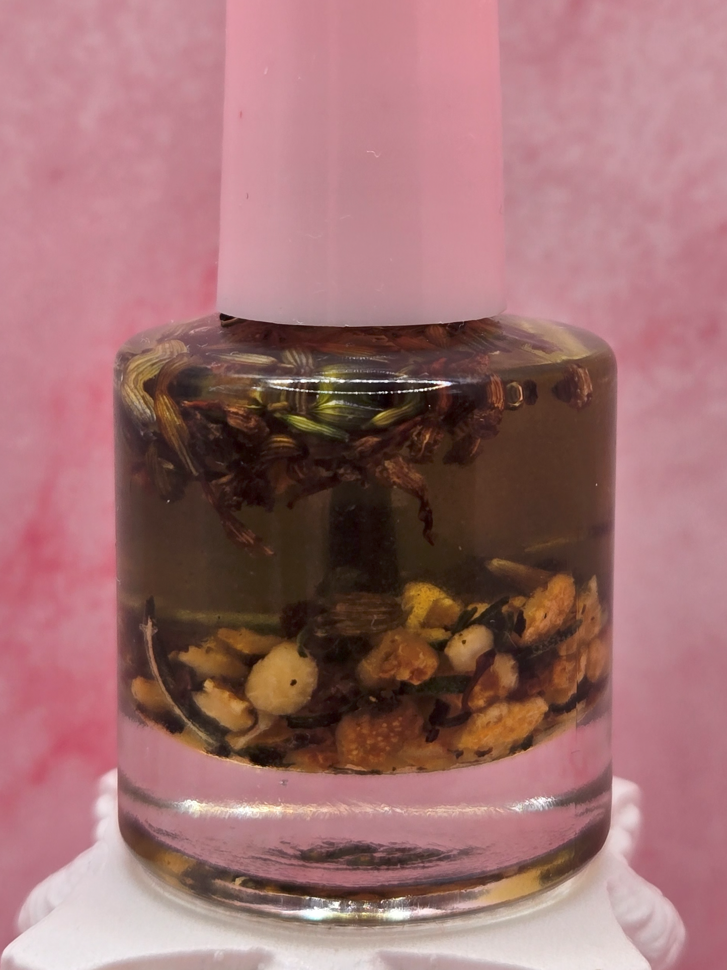 Dollhouse Botanicals Orange Lavender cuticle oil with floating flora in clear glass nail polish bottle with pink top